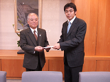 弊社社長・青木（右）より京都府・小石原副知事に寄付目録を贈呈